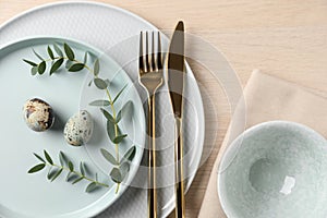 Festive Easter table setting with quail eggs on background, flat lay