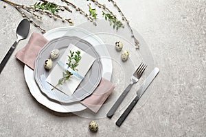 Festive Easter table setting with quail eggs on color background