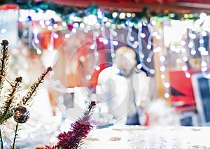 Festive fair decorated with garlands and christmas tree on blurred background