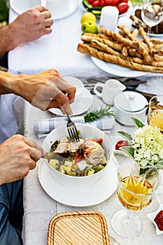 A festive family dinner or barbecue in the summer garden. Family leisure and celebration and food concept. People are eating