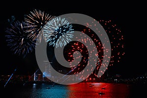 Festive fireworks in the city, the city embankment reflects the festive lights.