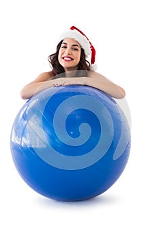 Festive fit brunette leaning on exercise ball