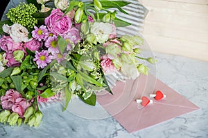 Festive flat lay arrangement of pale pink roses,white eustoma, envelope, hearts.Holiday card Festive mock up