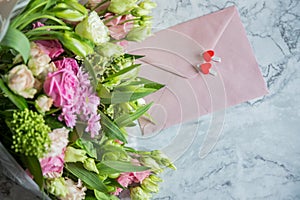 Festive flat lay arrangement of pale pink roses,white eustoma, envelope, hearts.Holiday card Festive mock up