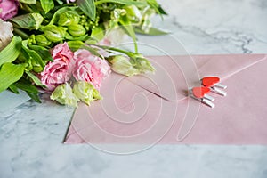 Festive flat lay arrangement of pale pink roses,white eustoma, envelope, hearts.Holiday card Festive mock up