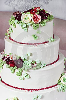 Festive four-level white elegant cake with cream flowers, wedding cake, cream flowers in the Malaysian technique