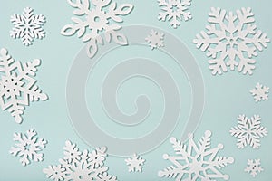 Festive frame made of wooden snowflakes on a blue background. Winter, Christmas, New Year concept