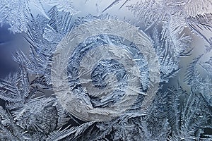 Festive frosty pattern with white snowflakes on a blue background on glass