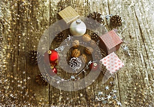 Festive Gifts with Boxes, Baubles, Pine Cones, Walnuts on Wooden Background.