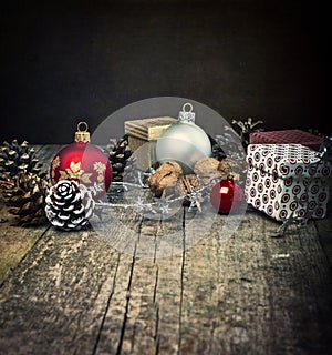 Festive Gifts with Boxes, Baubles, Pine Cones, Walnuts on Wooden Background.