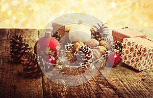 Festive Gifts with Boxes, Baubles, Pine Cones, Walnuts on Wooden Background.