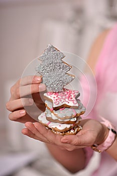 festive gingerbread in the form of a Christmas tree, stars in the hands of a girl.