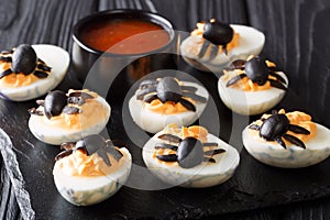 Festive Halloween appetizer: halved devil`s eggs decorated with