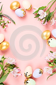 Festive Happy Easter background with decorated eggs, flowers, candy and ribbons in pastel colors on pink. Copy space