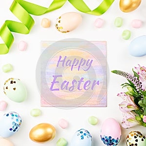 Festive Happy Easter background with decorated eggs, flowers, candy and ribbons in pastel colors on white. Copy space