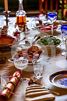 Festive Holiday Dinner Table with Elegant Dishes, Crystal Glassware, and Seasonal Decor photo