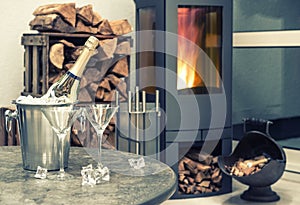 Festive home interior wirh champagne, two glasses and fireplace
