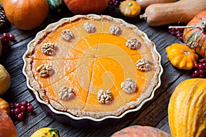 Festive Homemade Delicious Pumpkin pie with walnuts made for Thanksgiving and halloween, top view. Autumn composition.