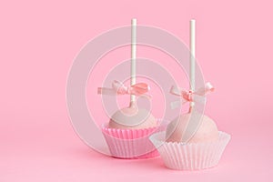 festive icing cake pop over pink background, close up