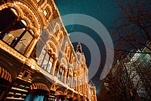 Festive illuminations in streets of city. New Year and Christmas lights decoration in snowy night, Red Square, Moscow, Russia.