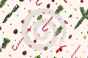 Festive inspired concept. Lovely christmas pattern made of candy canes, pine cone, pine branches, red, yellow berries and colorful