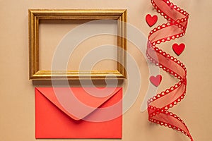 Festive laout arrangement for Valentines days. Red envelop, photoframe and ribbon with hearts. Creative composition photo