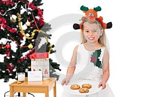 Festive little girl holding fresh cookies