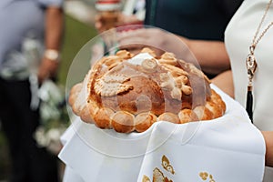 A festive loaf of bread. A product for traditional ceremonies. Decorated with flowers made of dough and salt shaker with