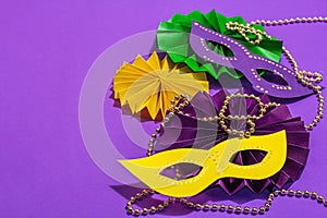 Festive Mardi Gras masquerade purple background. Fat Tuesday carnival, masks, beads, traditional decor