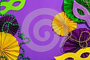 Festive Mardi Gras masquerade purple background. Fat Tuesday carnival, masks, beads, traditional decor