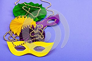 Festive Mardi Gras masquerade violet background. Fat Tuesday carnival, masks, beads, traditional decor