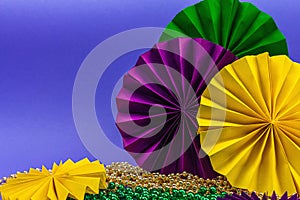 Festive Mardi Gras masquerade violet background. Fat Tuesday carnival, masks, beads, traditional decor