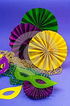 Festive Mardi Gras masquerade violet background. Fat Tuesday carnival, masks, beads, traditional decor