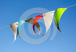 Festive multi-colored flags on a background of blue sky