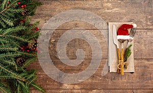 Festive New Year Christmas dinner concept. Christmas decorations and Cutlery on a dark rustic table. Christmas table place setting