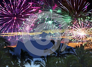 Festive New Years fireworks over the sea and mountains on tropical island