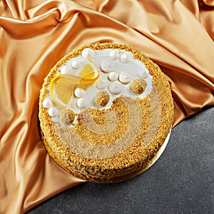 Festive orange honey cake on golden fabric background