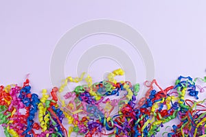 Festive party border or frame of colorful spiral streamers on pink background