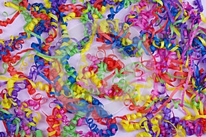 Festive party border or frame of colorful spiral streamers on pink background