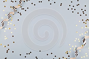 Festive party border or frame of silver spiral streamers and confetti on blue background