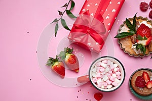 Festive pink background with cupcake, strawberries, chocolates, hot drink. Birthday celebration