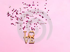 Festive pink background with spangles in the shape of heart. Concept Valentines Day