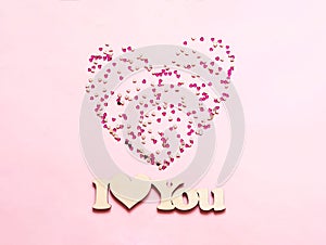 Festive pink background with spangles in the shape of heart. Concept Valentines Day or Mothers Day.n