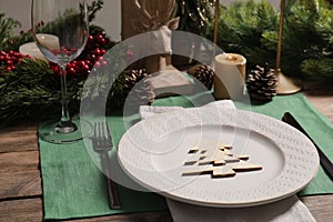 Festive place setting with beautiful dishware, cutlery and decor for Christmas dinner on wooden table