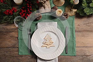 Festive place setting with beautiful dishware, cutlery and decor for Christmas dinner on wooden table, flat lay