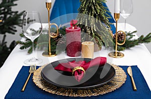 Festive place setting with beautiful dishware, cutlery and fabric napkin for Christmas dinner on white table