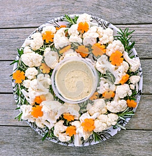 Festive raw food vegetable platter with hummus dip: cauliflower