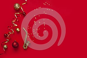 Festive red Christmas and New Year background with Miniature golden saxophone copy and Christmas decor. Top view, copy space, flat