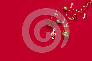 Festive red Christmas and New Year background with wooden musical notes symbols and Christmas decor. Top view, copy space, flat