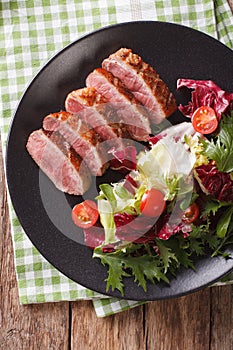 Festive roast duck breast and fresh mix green salad close-up. vertical top view